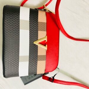 Red and black crossbody bag with a zipper closure and two interior pockets.